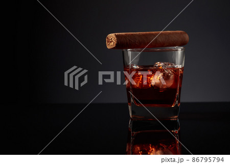 Glass of whiskey with ice and cigar. 86795794