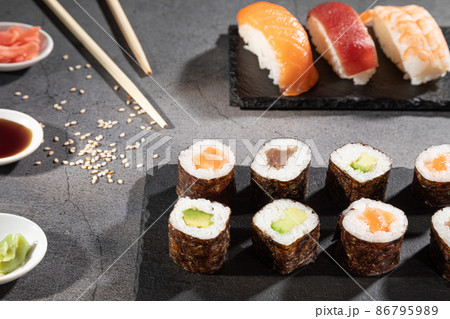 Closeup of fresh variety of sushi on dark background. Closeup of fresh variety of sushi on dark background. 86795989