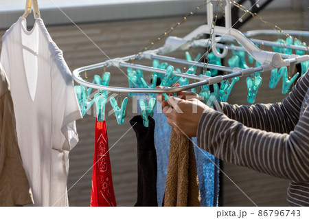 ベランダで女性が洗濯物を干しているところ 86796743