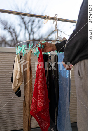 ベランダで男性が洗濯物を干しているところ 86796829