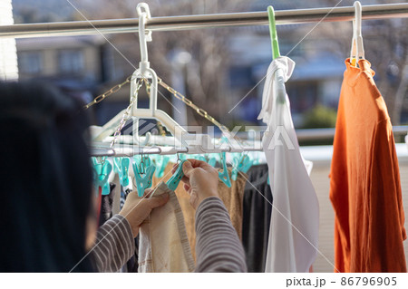 ベランダで女性が洗濯物を干しているところ ベランダで女性が洗濯物を干しているところ 86796905
