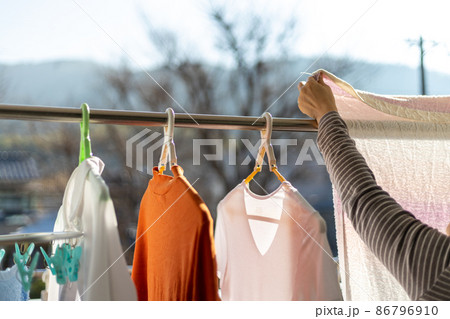 ベランダで女性が洗濯物を干しているところ ベランダで女性が洗濯物を干しているところ 86796910
