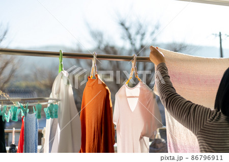 ベランダで女性が洗濯物を干しているところ ベランダで女性が洗濯物を干しているところ 86796911