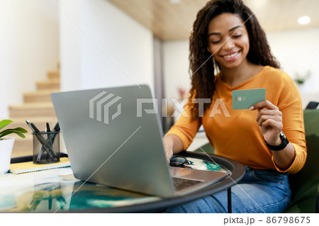 Happy woman holding debit credit card, using pc 86798675