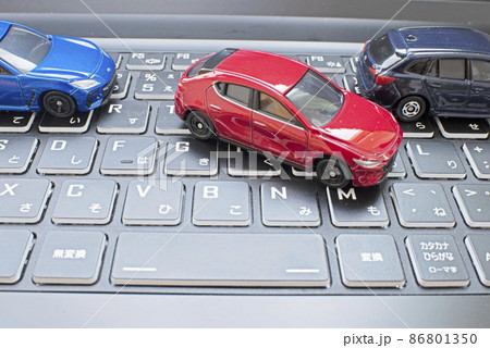 パソコンのキーボードの上を縦列駐車する赤い車 86801350