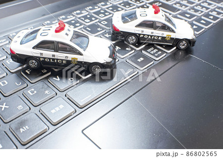 ノートパソコンのキーボード上の2台のパトカー 86802565