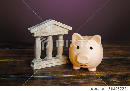 Piggy bank near the state building. Savings deposit in the bank. Use of investment instruments to increase funds, reduce inflationary risks. Budget. Tax collection. Financial system, commerce 86803225