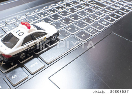 ノートパソコンのキーボードの上に乗っかっている1台のパトカー 86803687