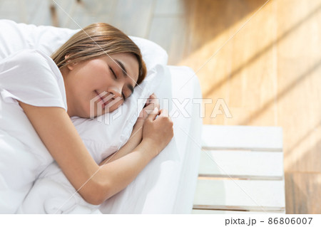 Beautiful Attractive Asian woman sleep and sweet dream lying on bed in cozy bedroom in the morning feeling so relax and comfortable.Healthy Young female sleep with bedtime at home.Healthcare Concept 86806007