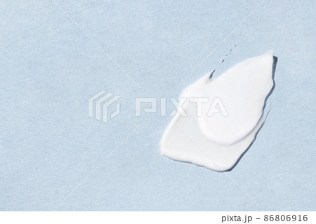 Smear of cosmetic cream on a blue background. Smear of cosmetic cream on a blue background. 86806916