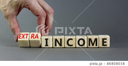 Extra income symbol. Businessman turns wooden cubes and changes concept words income to extra income. Beautiful grey table, grey background copy space. Business and extra income concept. Extra income symbol. Businessman turns wooden cubes and changes concept words income to extra income. Beautiful grey table, grey background copy space. Business and extra income concept. 86808038