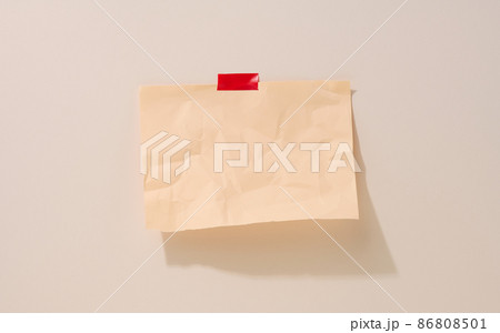 blank rectangular crumpled beige sheet of paper glued on a light beige background. Place for an inscription, announcement 86808501