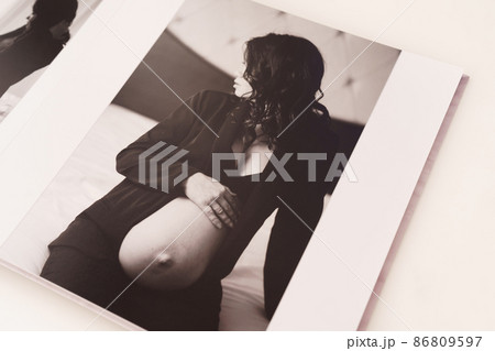 the pages of a photobook with a beautiful pregnancy photo shoot.  86809597