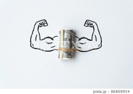 The concept of a strong world currency. Muscle hands with a bunch of us dollars money. 86809954