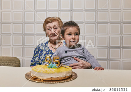 great-granddaughter and great-grandmother almost centenarian celebrating her birthday with joy. Concept of family, generational change great-granddaughter and great-grandmother almost centenarian celebrating her birthday with joy. Concept of family, generational change 86811531