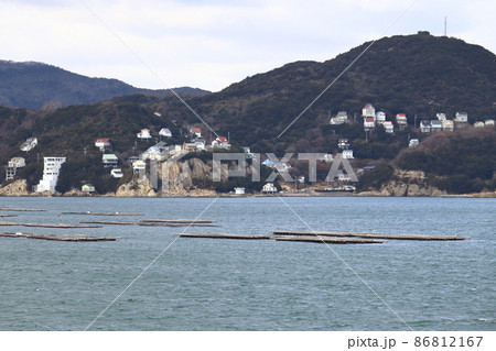日生湾の牡蠣養殖筏と崖に建設された別荘、住宅地（岡山県 鴻島） 86812167
