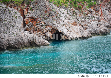 Colorful cliffs by the water edge. Natural reserve Zingaro. 86813191