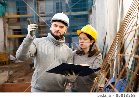 Engineers discussing blueprint at construction site 86813568