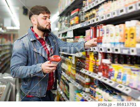 Young man looking for healthy pasta sauce 86813701