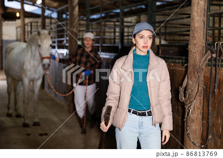 Woman horse rancher carrying working tool in hand 86813769