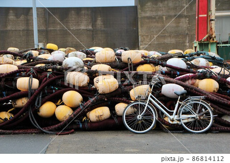 漁港に揚げられた漁網と自転車 86814112