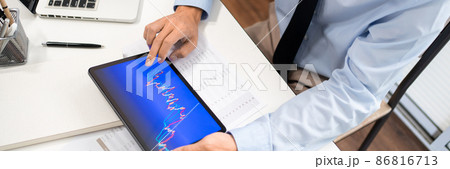 Working Man Conept The male employee sitting at his desk, holding a tablet, and touching the screen of his work 86816713