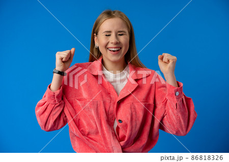 Excited thrilled woman portrait on blue studio background Excited thrilled woman portrait on blue studio background 86818326