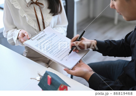 Cropped shot asian man signing contract with real estate agent. Concept of real estate investment. Cropped shot asian man signing contract with real estate agent. Concept of real estate investment. 86819468