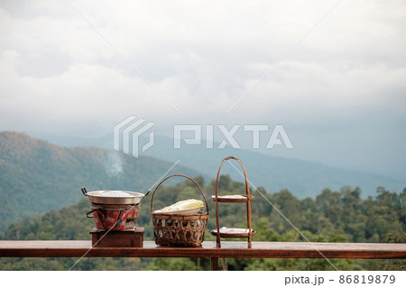 Pork or meat with vegetables and soup on the hot pan against mountain view background, Traditional Thai BBQ style is famous in Thailand Pork or meat with vegetables and soup on the hot pan against mountain view background, Traditional Thai BBQ style is famous in Thailand 86819879