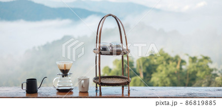 arabica coffee brewing by Vintage coffee drip equipment set on wooden table in the morning with mountain and nature background 86819885