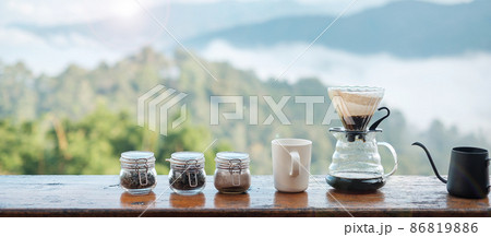 arabica coffee brewing by Vintage coffee drip equipment set on wooden table in the morning with mountain and nature background 86819886