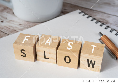 「FAST」「SLOW」と書かれた積み木、ペン、ノート、コーヒーカップ 86820128