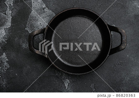 Vintage cast iron skillet with copy space for text or food with copy space for text or food, top view flat lay , on black dark stone table background 86820363