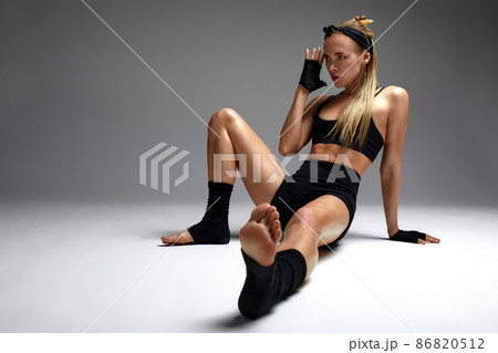 Animal instinct fitness female instructor showing his incredible flexibility with an animal flow move in studio against a gray background Animal instinct fitness female instructor showing his incredible flexibility with an animal flow move in studio against a gray background 86820512