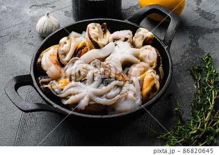 Raw mix seafood cocktail with shrimps, prawns, mussels, squids, on gray stone table background Raw mix seafood cocktail with shrimps, prawns, mussels, squids, on gray stone table background 86820645