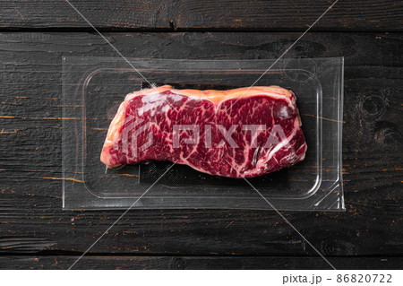 New-York steak pack, on black wooden table background, top view flat lay New-York steak pack, on black wooden table background, top view flat lay 86820722