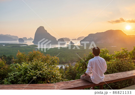 Happy traveler man enjoy Phang Nga bay view point, alone Tourist sitting and relaxing at Samet Nang She, near Phuket in Southern Thailand. Southeast Asia travel, trip and summer vacation concept 86821133