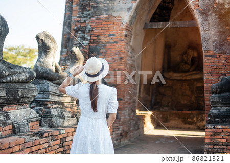 Tourist Woman in white dress visiting to ancient stupa in Wat Chaiwatthanaram temple in Ayutthaya Historical Park, summer, Asia and Thailand travel concept Tourist Woman in white dress visiting to ancient stupa in Wat Chaiwatthanaram temple in Ayutthaya Historical Park, summer, Asia and Thailand travel concept 86821321