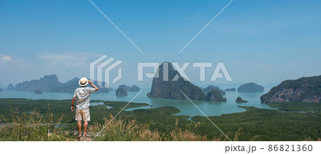 Happy traveler man enjoy Phang Nga bay view point, alone Tourist standing and relaxing at Samet Nang She, near Phuket in Southern Thailand. Southeast Asia travel, trip and summer vacation concept Happy traveler man enjoy Phang Nga bay view point, alone Tourist standing and relaxing at Samet Nang She, near Phuket in Southern Thailand. Southeast Asia travel, trip and summer vacation concept 86821360