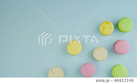 Top view of colorful french macarons on pastel blue background Top view of colorful french macarons on pastel blue background 86822240