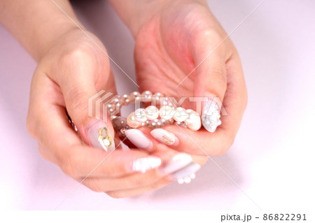 パールのネックレスを持つ女性の手 パールのネックレスを持つ女性の手 86822291