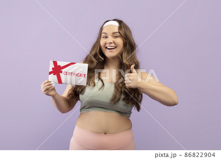 Happy millennial european plus size female in uniform show certificate and thumb up isolated 86822904