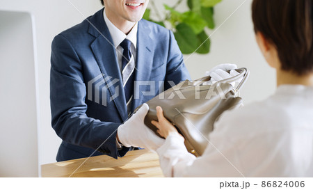 バッグを査定する鑑定士と客 86824006