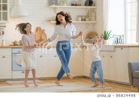 Mom and her daughters are dancing. 86824498