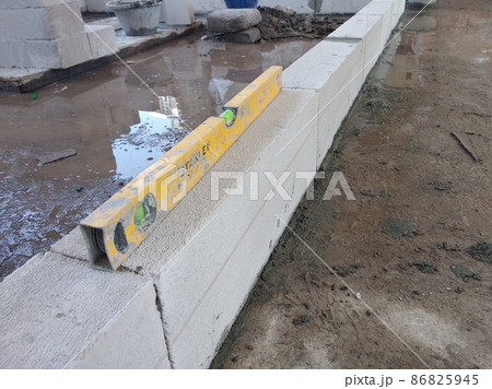 SEREMBAN, MALAYSIA -FEBRUARY 2, 2021: Blockwork by construction workers at the construction site. The bricks are stacked to form the walls as designed by the architect. SEREMBAN, MALAYSIA -FEBRUARY 2, 2021: Blockwork by construction workers at the construction site. The bricks are stacked to form the walls as designed by the architect. 86825945