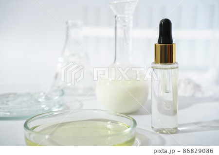 laboratory dishes and glassware on a lab table. fermentation, fermented beauty skin care. dropper bottle of solution or serum for anti age treatment. 86829086