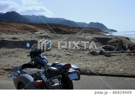 海岸の砂山に佇むサイドカー 86829409