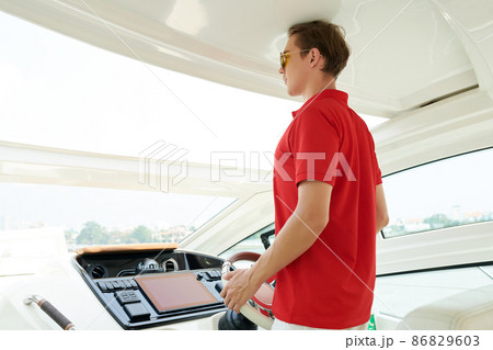 Man Navigating Luxurious Sail Boat Man Navigating Luxurious Sail Boat 86829603
