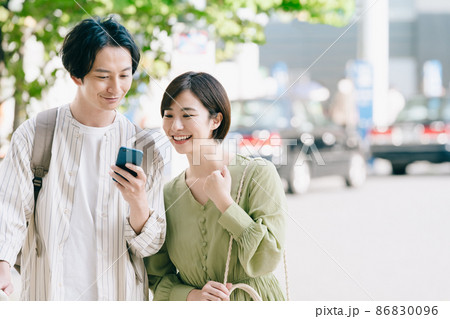 スマホを手に持つ男女 スマホを手に持つ男女 86830096
