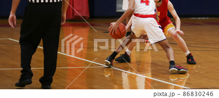 Basketball player dribbling the ball making a move on the defender 86830246